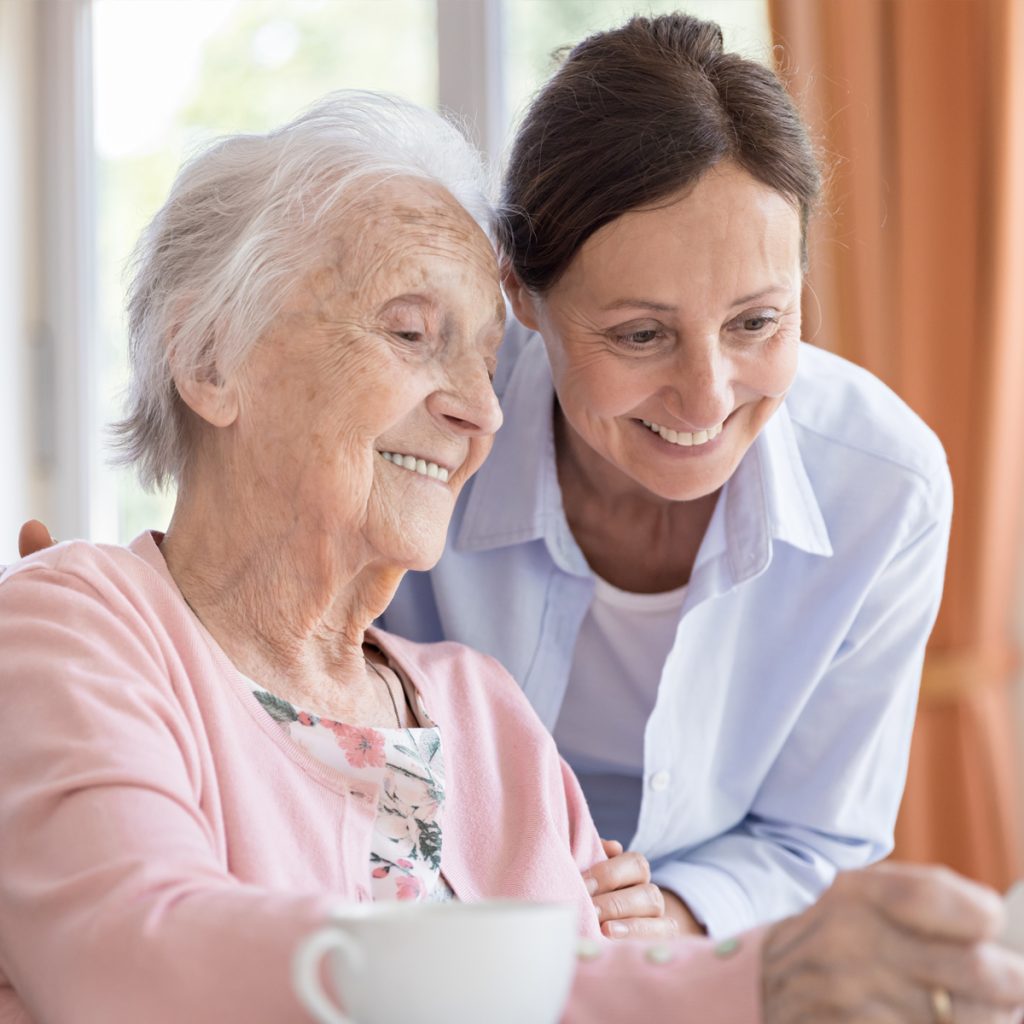Sunny Vista Senior Living Community in Colorado Springs, CO - sunny vista caregiver looking at puzzle with senior woman