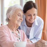 Sunny Vista Senior Living Community in Colorado Springs, CO - sunny vista caregiver looking at puzzle with senior woman