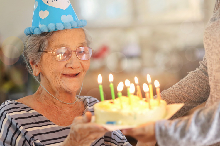 Sunny Vista Senior Living Community in Colorado Springs, CO - sunny vista senior woman with birthday cake and candles