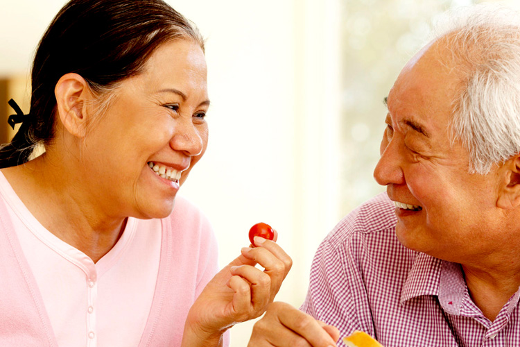 Sunny Vista Senior Living Community in Colorado Springs, CO - sv senior couple smiling about a cherry tomato