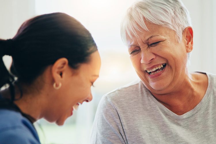 Sunny Vista Senior Living Community in Colorado Springs, CO - senior woman laughing with caregiver