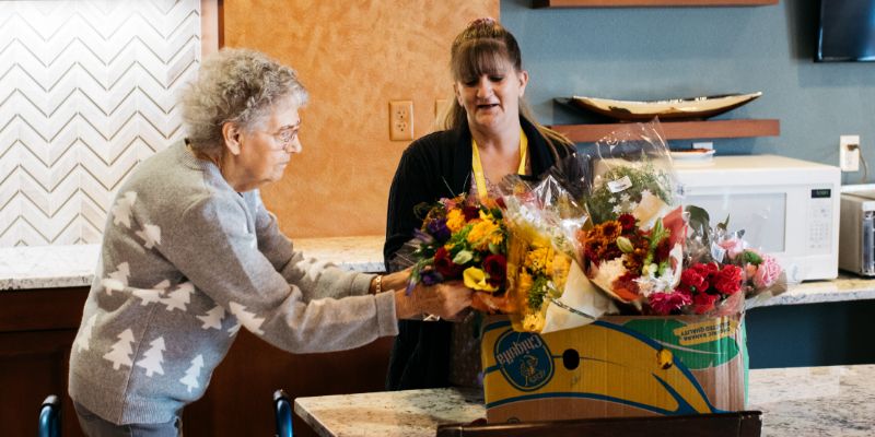 Sunny Vista Senior Living Community in Colorado Springs, CO - the retreat resident and flowers landscape