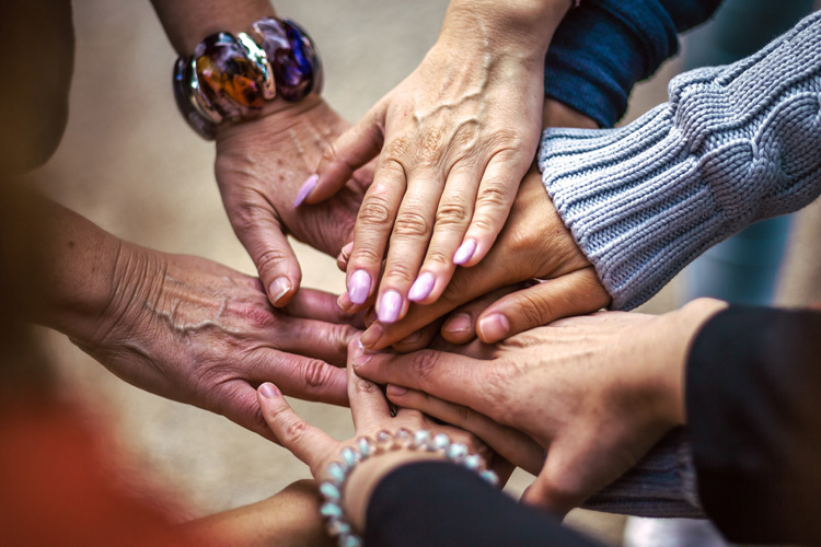 sunny vista older adults in a circle with hands stacked Sunny Vista Senior Living Community in Colorado Springs, CO - sunny vista older adults in a circle with hands stacked